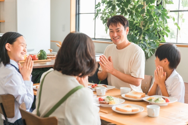 食卓でご飯を食べる家族