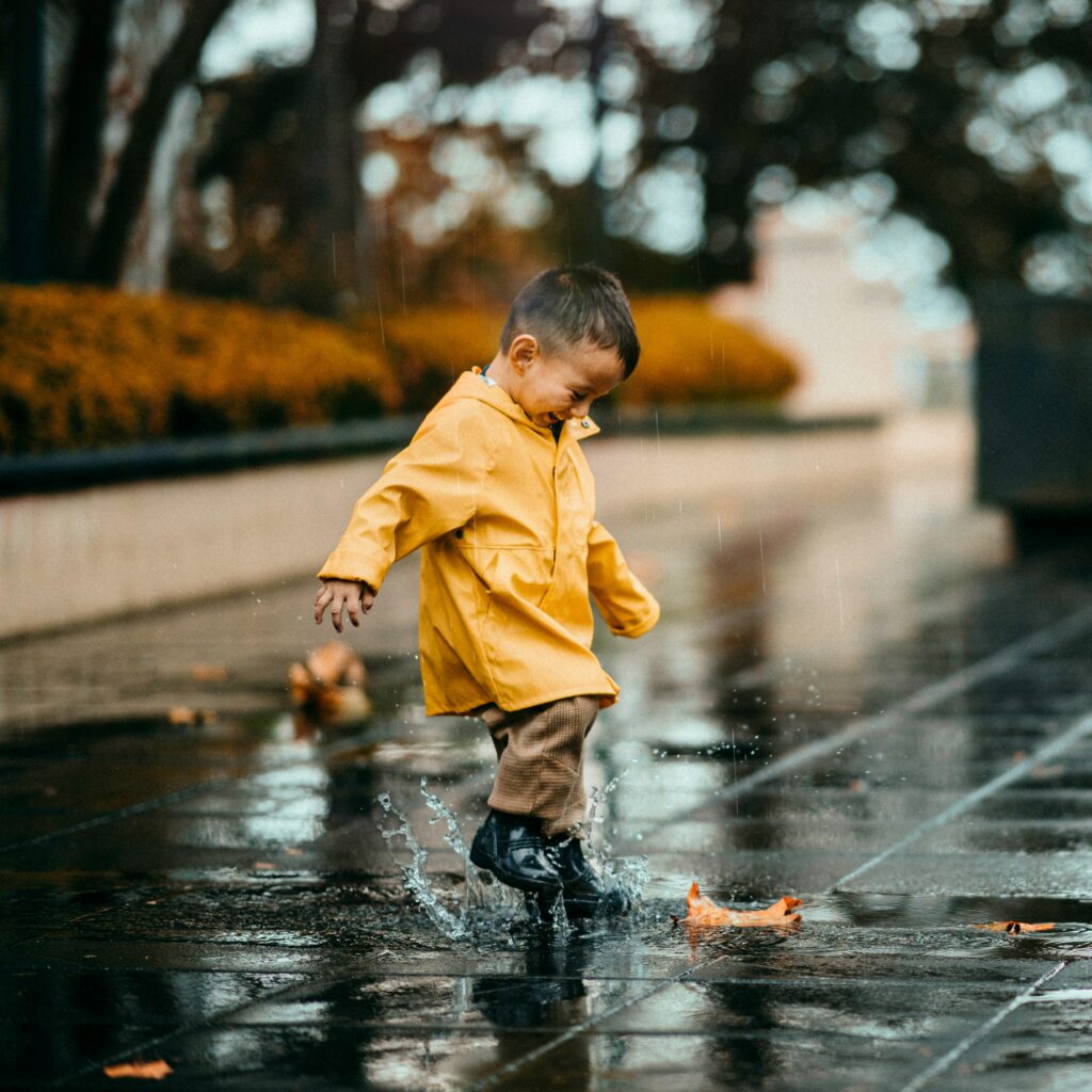 雨の日にレインウェアを着て遊ぶ子供