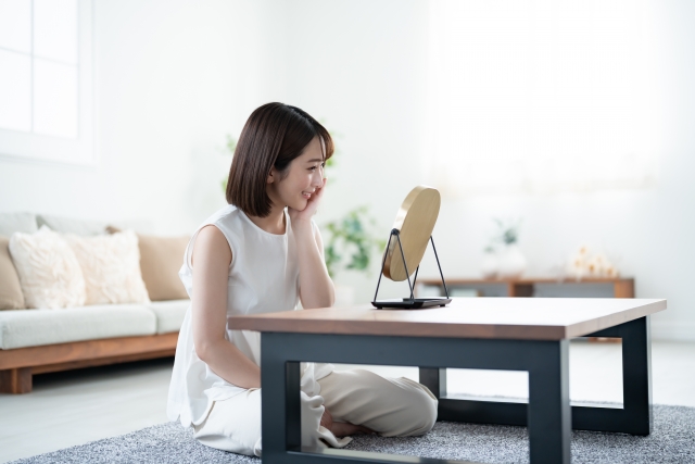 鏡の前でスキンケアをする女性