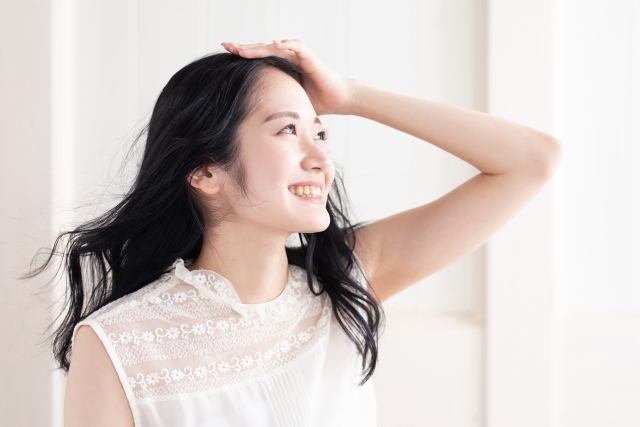 髪をなびかせるロングヘアの女性