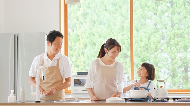 パパとママと女の子の3人家族で、一緒にキッチンに立って料理をしている