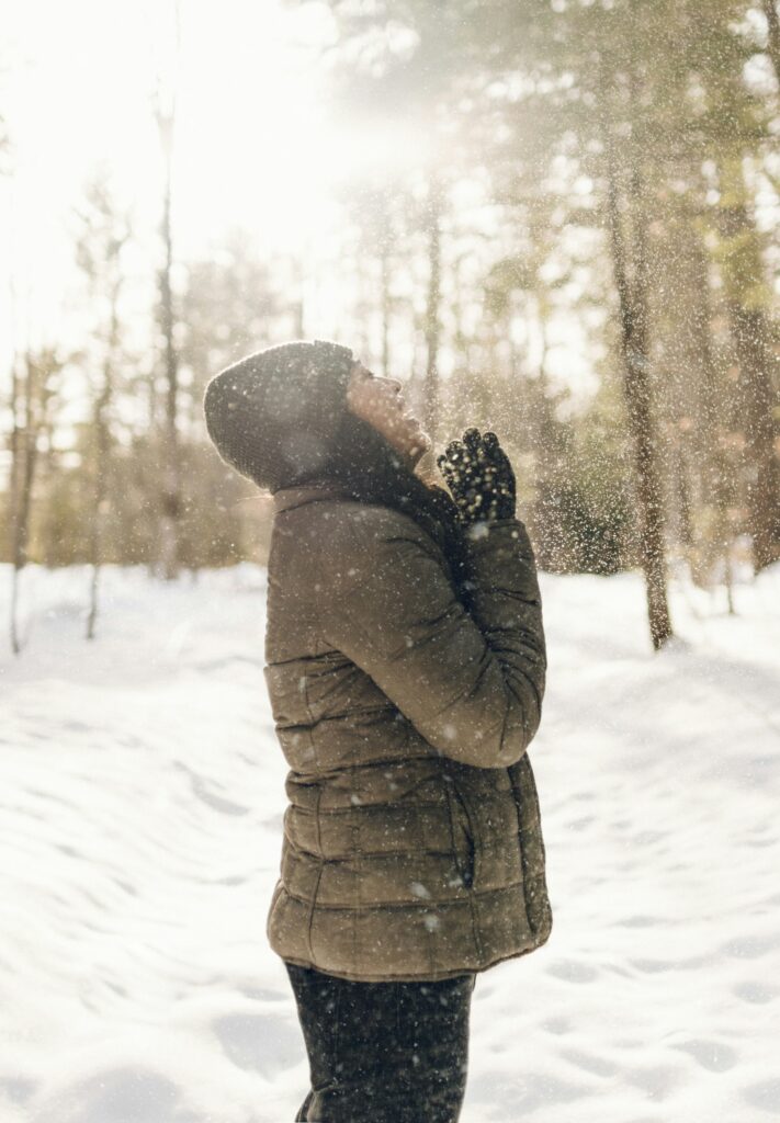 雪の中で空を仰ぐ女性