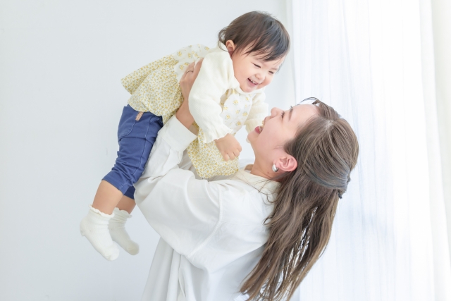 子どもを抱き上げ、笑い合う親子