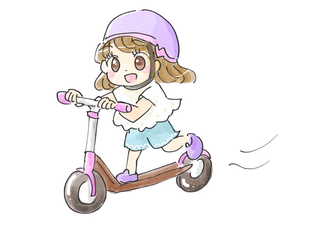 ヘルメットをかぶってキックボードを楽しむ女の子