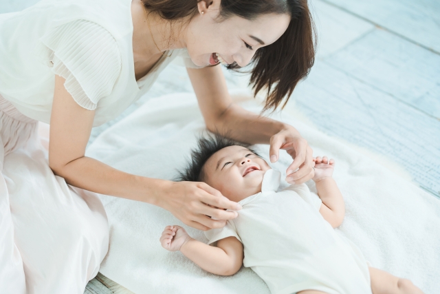 顔を合わせて笑顔で遊ぶママと赤ちゃん
