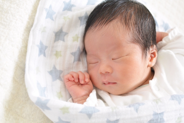 おくるみに包まれて眠っている赤ちゃん