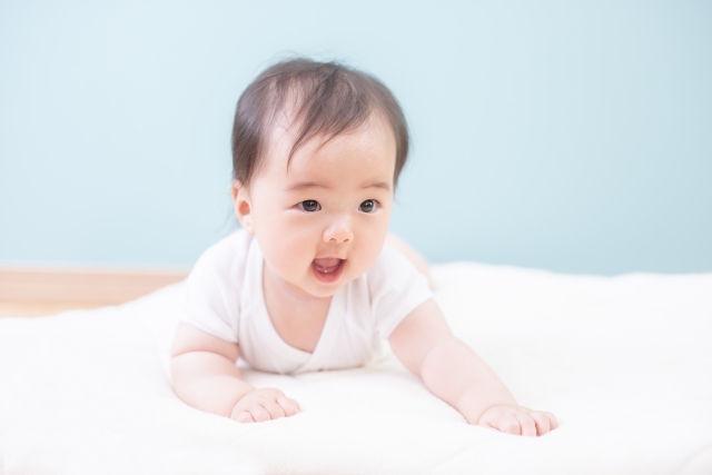 寝返りをして笑顔を見せる赤ちゃん