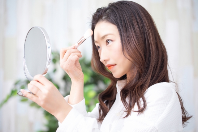 メイクブラシでメイクをする女性