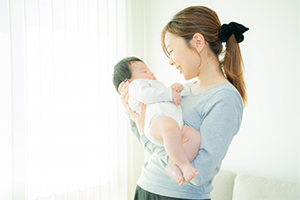 赤ちゃんを抱っこして微笑む女性