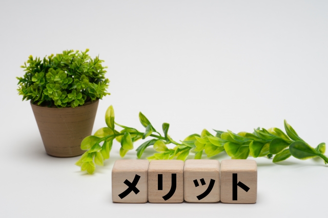 オブジェに書かれたメリットの文字と観葉植物