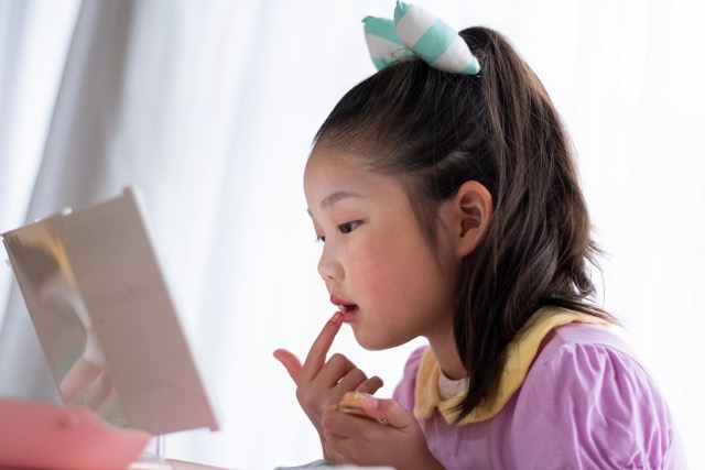 小学生の女の子がメイクをしている姿