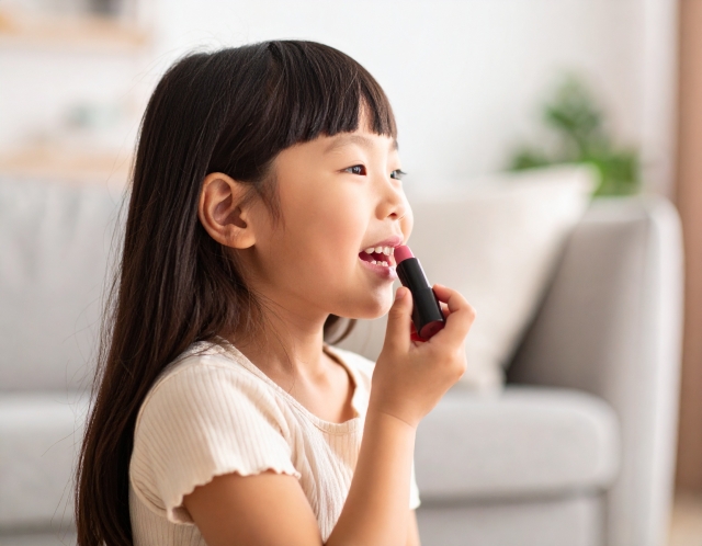 小学生の女の子がリップを塗っている姿