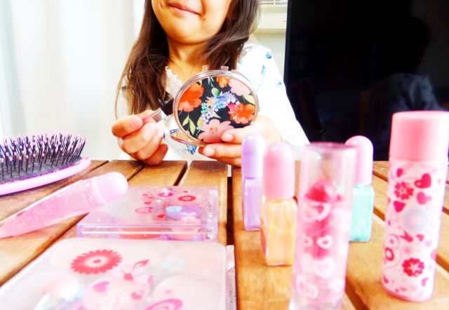 ピンク色にお花やハートのかわいらしいデザインが入ったリップやアイシャドウなどのキッズコスメ