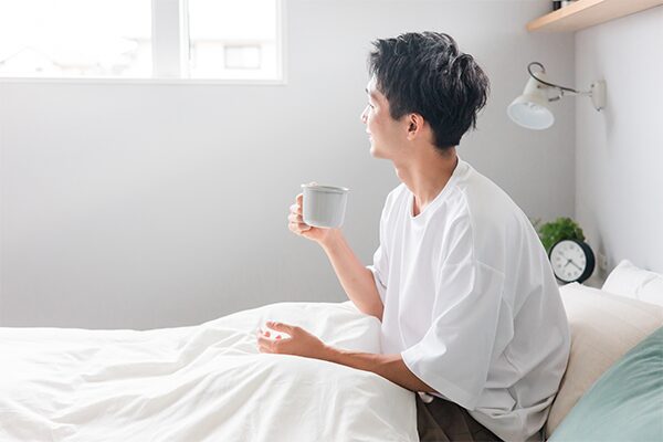 ベッドでリラックスする男性の様子