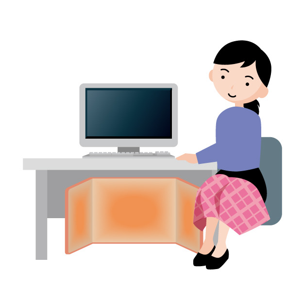 パネルヒーターで温まりながらデスクワークをする女性