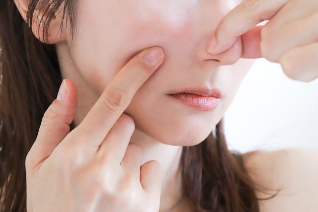 鼻をつまむ女性