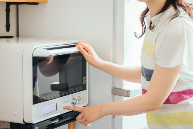 電子レンジを使う女性
